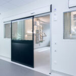 Automatic sliding hospital doors with glass panels, providing a hygienic and efficient entrance to a sterile medical environment.